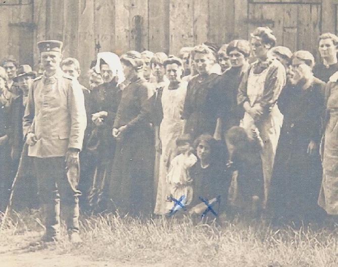 Leuvense gevangenen in het kamp van Munster. De twee blauwe kruisjes geven de plaats van Marie-Thérèse Delfosse en de tweejarige Henriëtte Peeters aan. Zij werden op 26 augustus 1914 naar een Duits gevangenekamp gedeporteerd (foto Europeana databank)