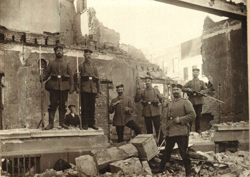 Duitse manschappen poseren bij een uitgebrand gebouw op het stationsplein in Leuven (foto Stadsarchief Leuven)