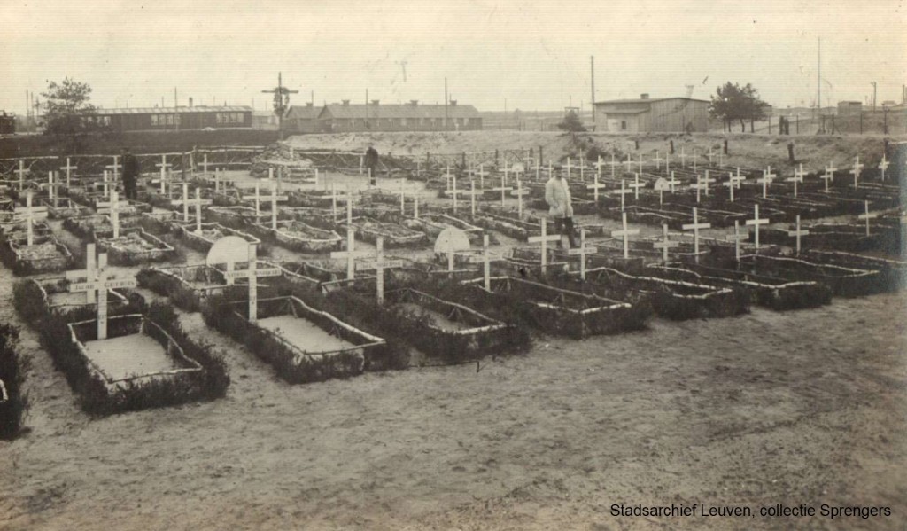 De begraafplaats van kamp Soltaumet het graf van Charles Schots. Op de achtergrond zijn de barakken van het kamp zichtbaar (foto Stadsarchief Leuven)